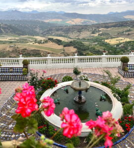 Garten der Casa Don Bosco in Ronda mit Brunnen, bunten Fliesen und Blick über Andalusien