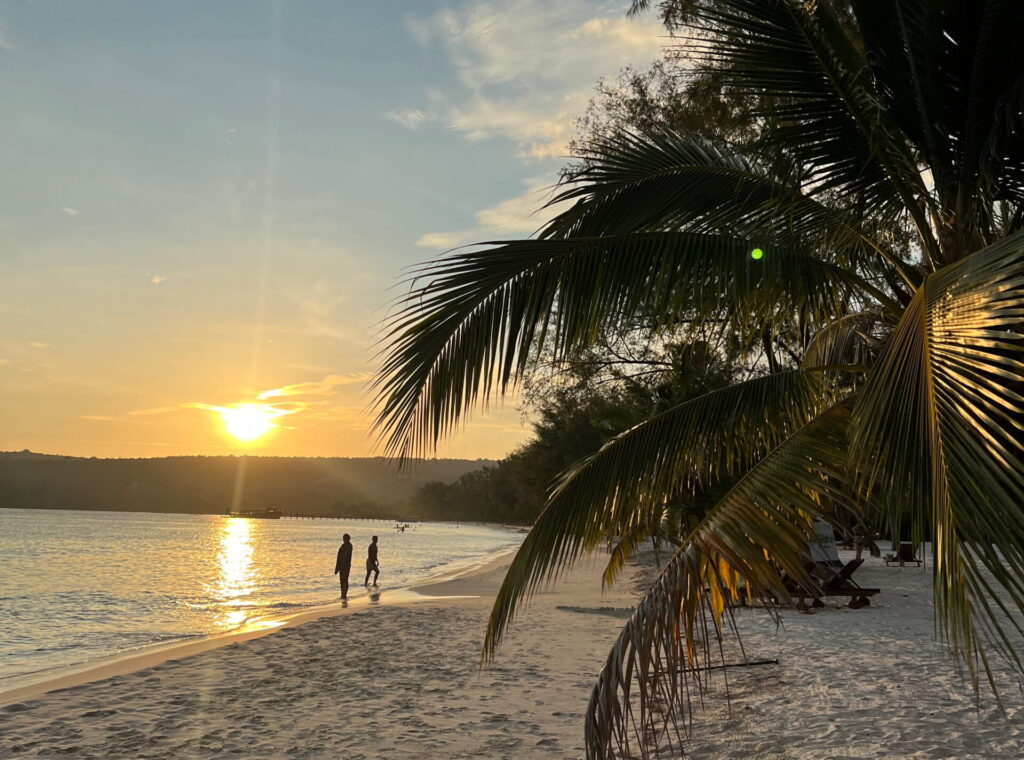 Sonnenuntergang am weißen Sandstrand von Koh Rong in Kambodscha mit Palmen und türkisblauem Meer