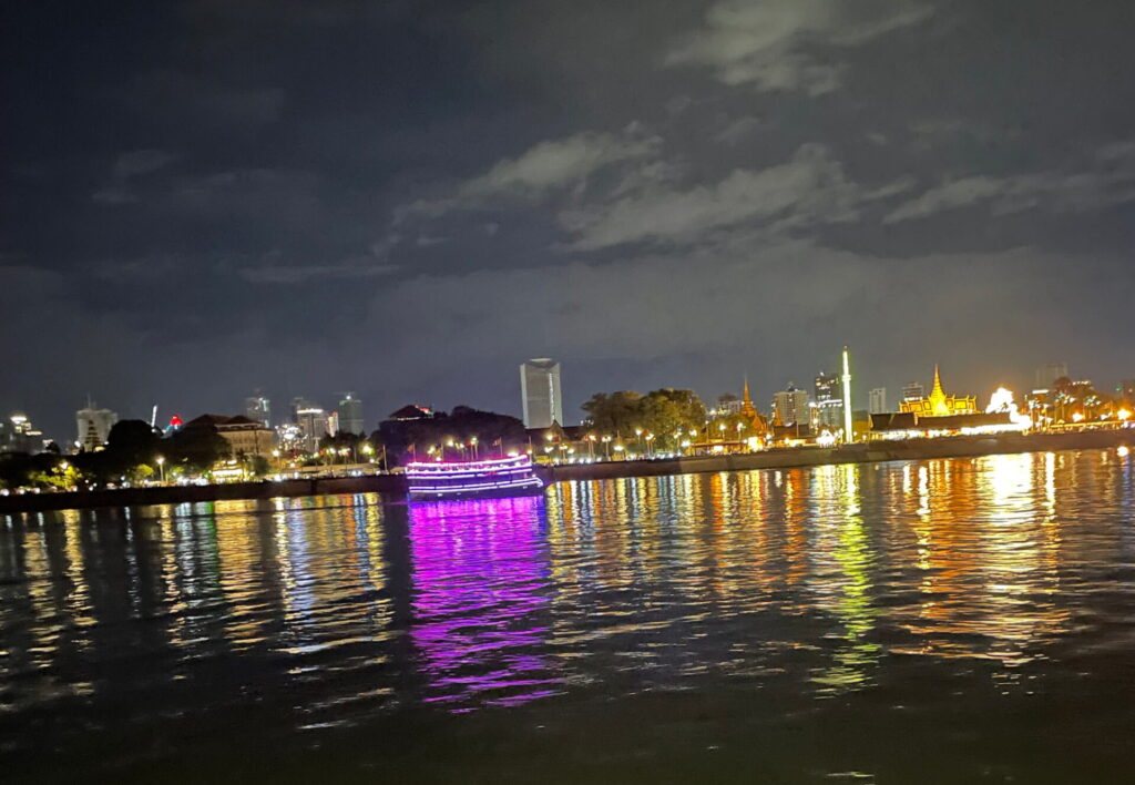 Abendliche Bootsfahrt auf dem Mekong mit Blick auf die beleuchtete Skyline von Phnom Penh