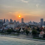 Phnom Penh Sonnenuntergang über Phnom Penh mit Blick vom Rooftop-Pool auf den Königspalast und die Skyline der kambodschanischen Hauptstadt