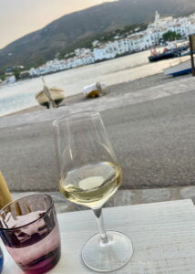 Glas Weißwein mit Blick auf Cadaqués an der Costa Brava