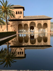 Palacio del Partal in der Alhambra mit Palmen und Spiegelung im Wasserbecken